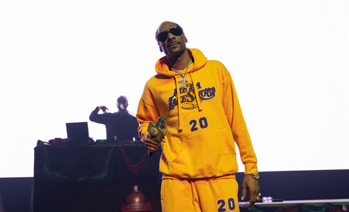 Low angle view of man standing against yellow background