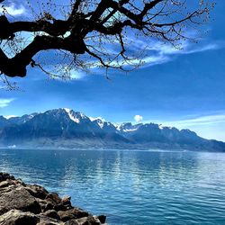 Scenic view of lake and mountains against blue sky