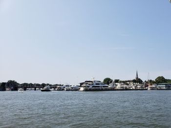 Sea by buildings against clear sky