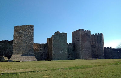 Old ruins in field against clear blue sky