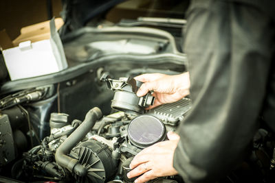 Midsection of mechanic working in garage