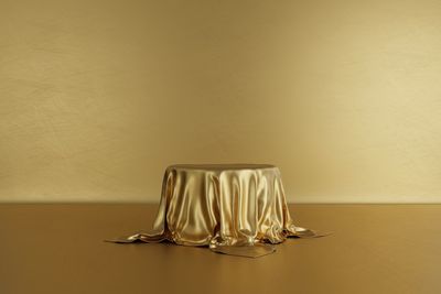 Close-up of empty glass on table against wall