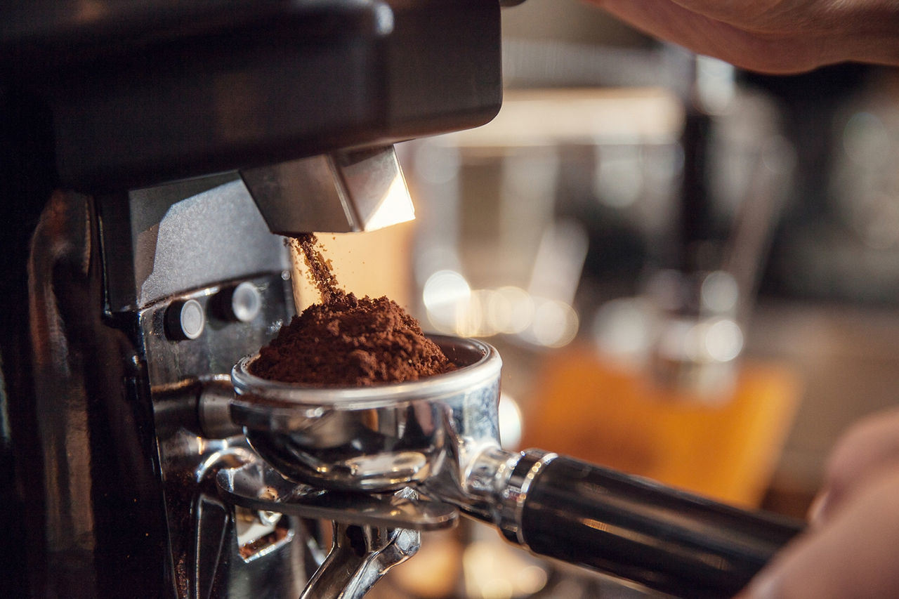 CLOSE-UP OF HAND HOLDING COFFEE CUP WITH TEA