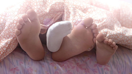 Two sisters show their feet at the end of the bed .photo with soft focus on their feet.