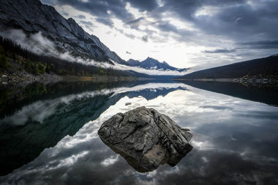 Scenic view of lake by mountains against sky