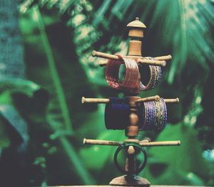 Close-up of bangles hanging on wood against trees