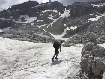 Full length of man walking on snowcapped mountain