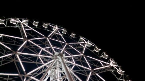 Low angle view of illuminated ferris wheel against sky at night