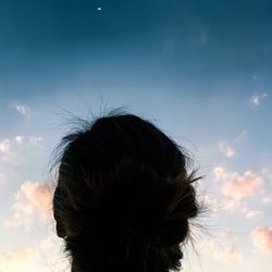 Low angle view of woman looking at crescent moon in sky