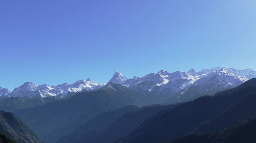 Scenic view of snowcapped mountains against clear blue sky