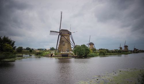 Traditional windmill by windmills against sky