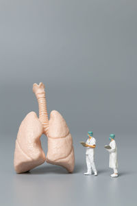 Close-up of figurine on table against white background