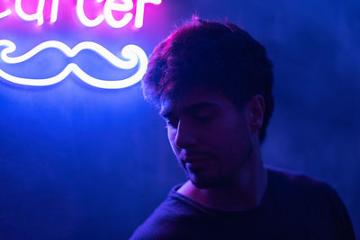 Portrait of young man illuminated with neon lights