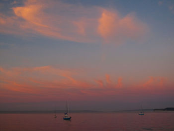 Boat sailing in sea at sunset