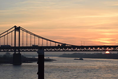 View of bridge over river at sunset