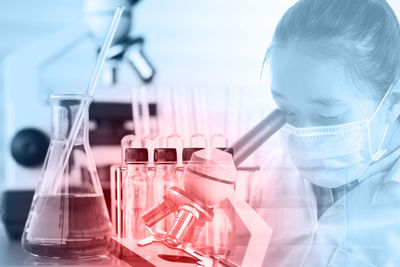 Close-up of female doctor looking in microscope in laboratory