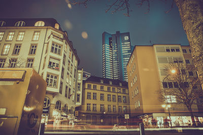 Low angle view of illuminated buildings against sky at night