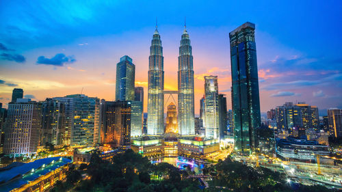 Illuminated buildings in city against sky