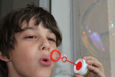 Close-up portrait of boy holding bubbles