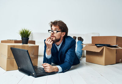 Young man using mobile phone while sitting on table