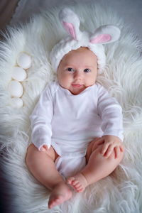 Baby with rabbit ears on a white background with easter eggs