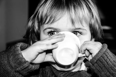 Close-up of girl drinking at home