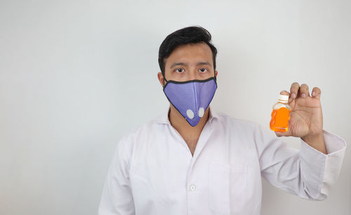 Portrait of man standing against white background