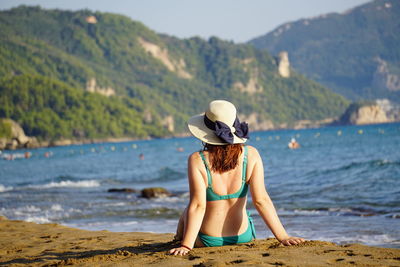 Side view of woman sitting at beach