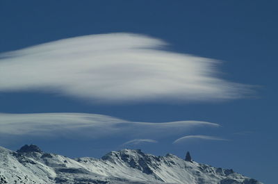 Snow covered mountains against blue sky