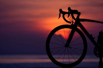 Silhouette bicycle against sky during sunset