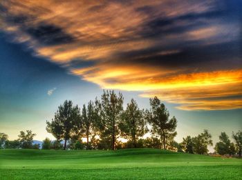 Scenic view of grassy field against cloudy sky