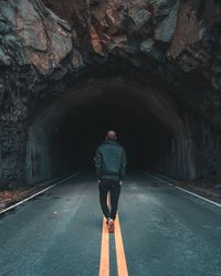 Rear view of man standing in tunnel