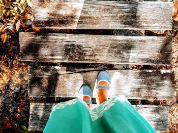 Low section of woman standing on boardwalk