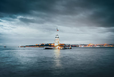 Ship in sea against cloudy sky