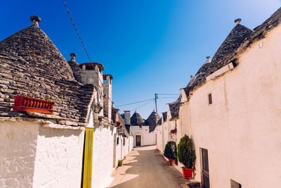 Street amidst buildings against blue sky