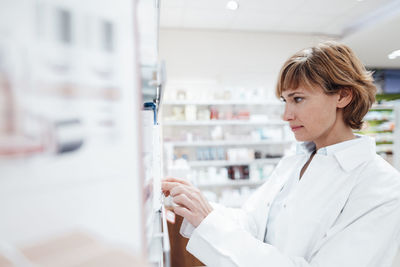 Female pharmacist searching medicine at pharmacy