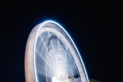 Low angle view of illuminated ferris wheel against sky at night