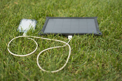 Mobile phone charging on grassy field