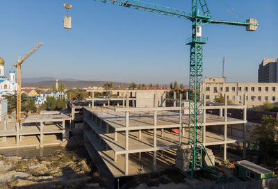 Construction site by buildings against clear sky
