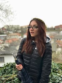 Young woman wearing jacket standing outdoors