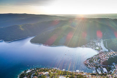 Aerial view of lake by mountain against sky