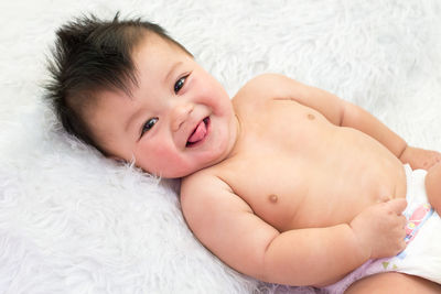 Portrait of cute baby boy lying on fur