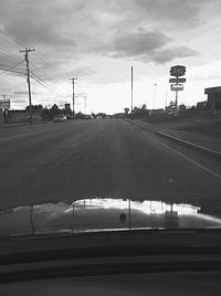 Empty road against cloudy sky