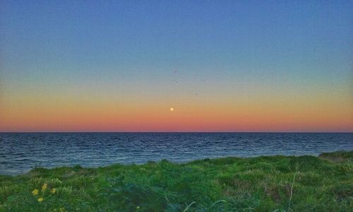 Scenic view of sea against clear sky during sunset