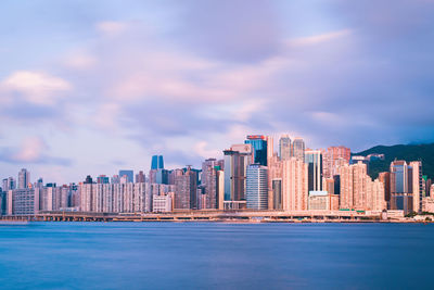 Sea by buildings against sky in city