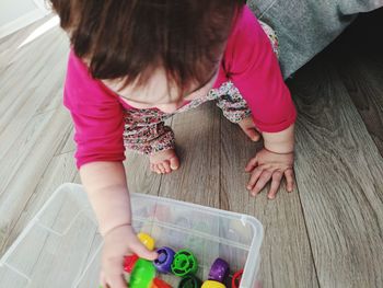 High angle view of girl playing with toy on floor