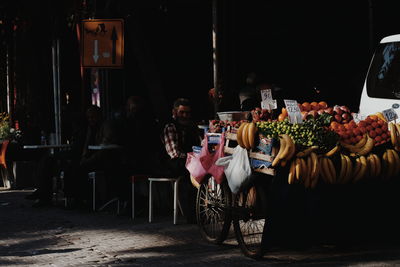 Man sitting at market stall in city