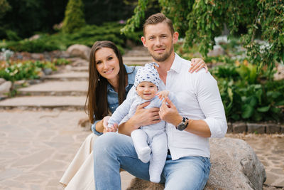 Portrait of a caucasian family enjoying happy love, father and mother holding a cute little son