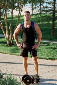 Portrait of young man exercising in park