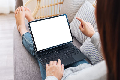 Midsection of woman using laptop at home